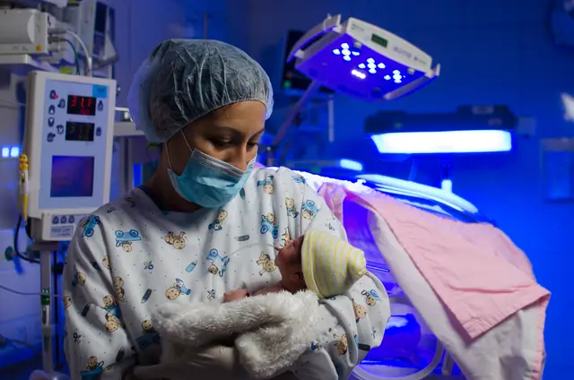 Enfermera cuidando a un recién nacido en la UCI neonatal